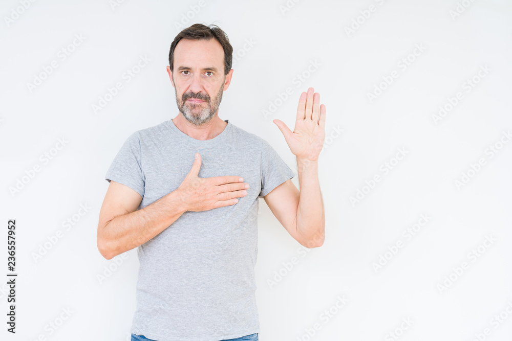 Handsome senior man over isolated background Swearing with hand on chest and open palm, making a loyalty promise oath