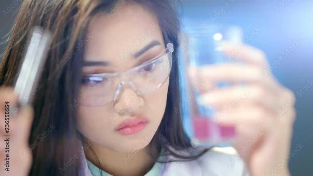 Asian female biologist conducting chemical experiments in laboratory close-up Asian female biologist conducting chemical experiments in laboratory close-up