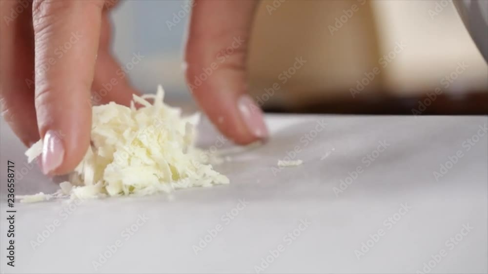 A little Parmesan Pile is Laid on Baking Paper (Hand Visible), Closeup A little Parmesan Pile is Laid on Baking Paper (Hand Visible), Closeup
