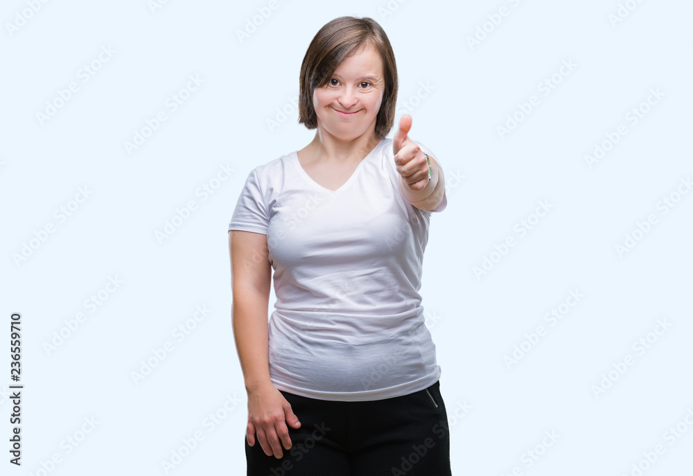 Young adult woman with down syndrome over isolated background doing happy thumbs up gesture with hand. Approving expression looking at the camera with showing success. Young adult woman with down syndrome over isolated background doing happy thumbs up gesture with hand. Approving expression looking at the camera with showing success.