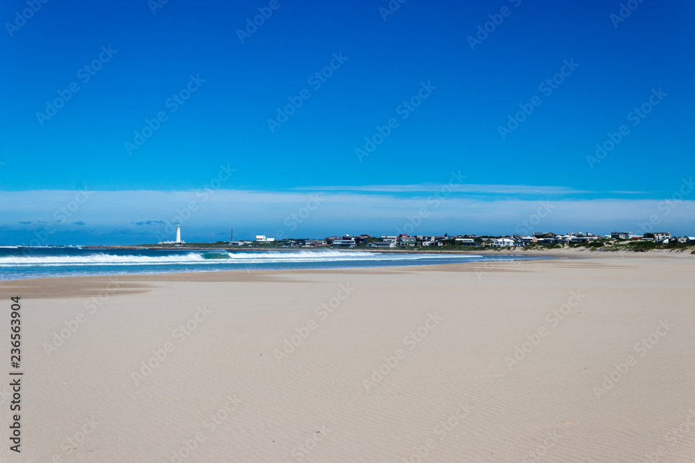 Beach and sea with lighthouse in distance