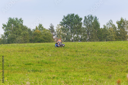 Elegant woman riding quadrocycle on spring field