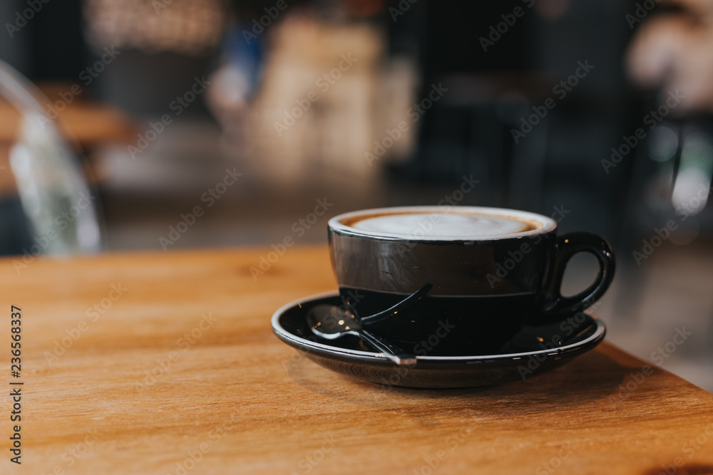 hot coffee in black cup on wooden table.