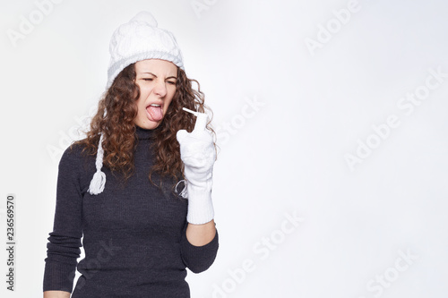 Portrait of young cute curly haired woman express disgust on face, being sick, suffering from pain in throat, hates treatment, grimaces as going to spray medicine, isolated over white blank wall.