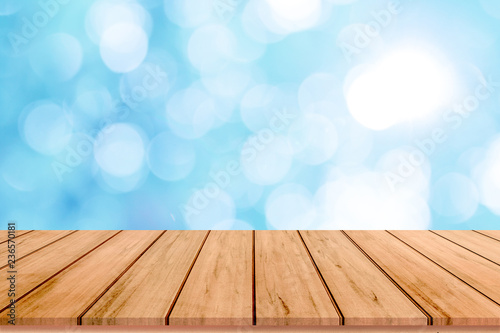 Wood table or wood floor with abstract blue bokeh background for product display