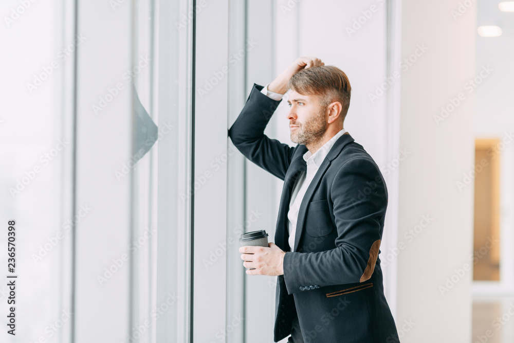 Coffee break after work in the office. Bright interior with a businessman. Coffee break after work in the office. Bright interior with a businessman.