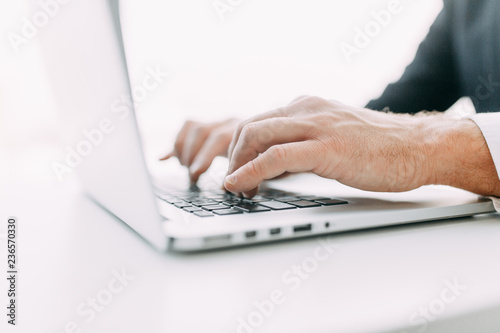 Hands at work on a laptop with bokeh. Business situation, isolated background.