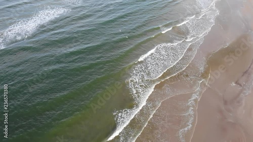 Aerial view of the North Sea shoreline with rollig waves and seabirds outside L√∏kken, Denmark photo