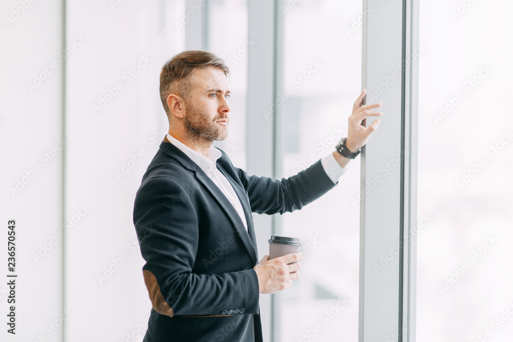 Coffee break after work in the office. Bright interior with a businessman. Coffee break after work in the office. Bright interior with a businessman.