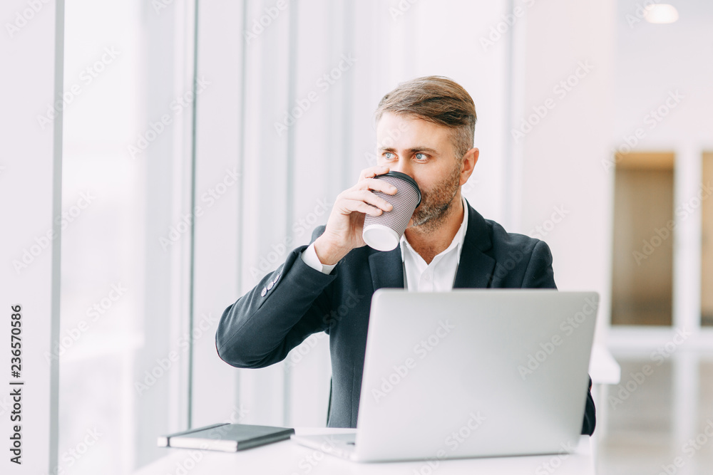 Coffee break after work in the office. Bright interior with a businessman. Coffee break after work in the office. Bright interior with a businessman.