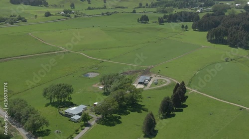 Areal footage abive a rural area revealing a small farm house hidden behid some trees. 4ki video quality photo