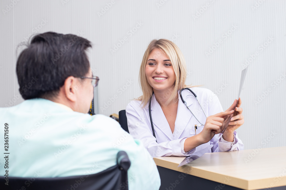Woman doctor and male patient discussing something while sitting at the desk at hospital. Woman doctor and male patient discussing something while sitting at the desk at hospital.
