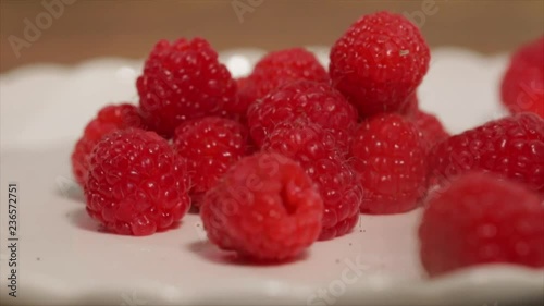 Raspberries Falling Onto a small Pile of Raspberries, Closeup