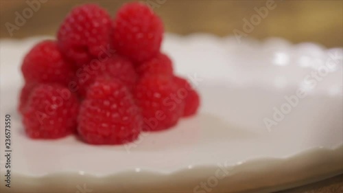 A Pile of Raspberries Lying on a Rotating White Plate, Closeup