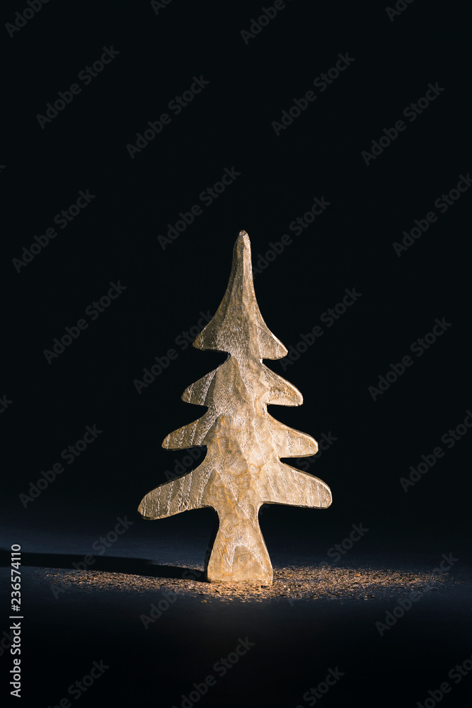 Mini golden Christmas tree with glitter on black background Mini golden Christmas tree with glitter on black background