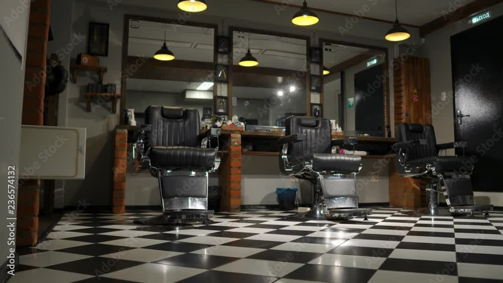 Vintage hanging lamps in hairdressing salon. Ceiling retro lamp in barber shop. Barber pole. Hair salon interior. Metal ceiling lights in barbershop