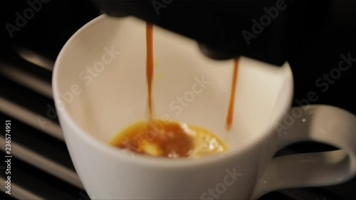 A Cup is Filled with Coffee out of a Coffee Machine, Closeup, High Angle
