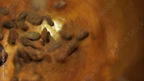 Cacao Beans are Falling into a Rotating Golden Cauldron, Closeup