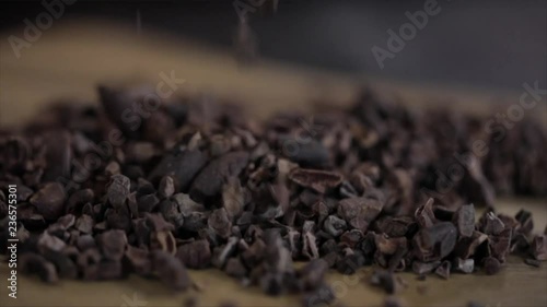 Cacao Nibs or Chips Falling onto a Wooden Table, Closeup