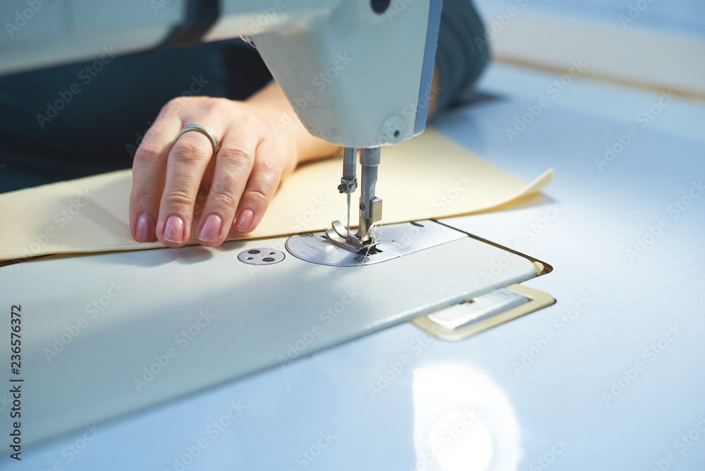 A woman sews on an electric sewing machine.