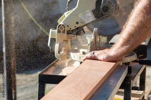 Man doing home renovations cutting wood with a saw