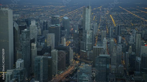 Aerial illuminated view at sunrise of Trump Tower Aon Center Chicago Skyscraper buildings Financial District and skyline suburbs Illinois 