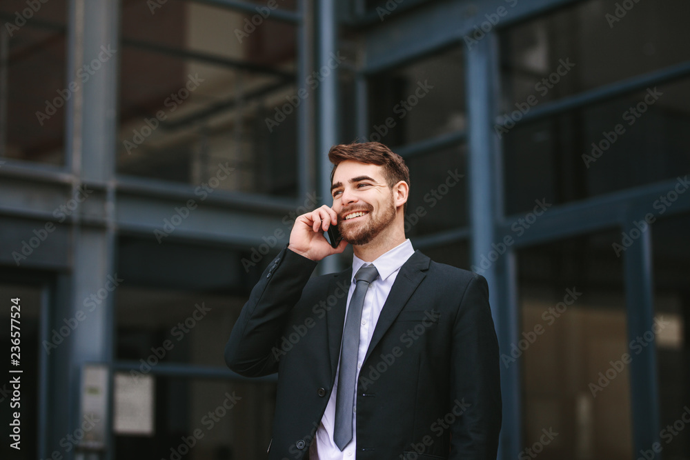 Businessman walking outdoors and talking on phone Businessman walking outdoors and talking on phone