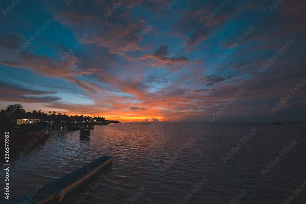Sunset dramatic sky on tropical desert beach, coral reef reflection no people, travel destination, Indonesia Wakatobi