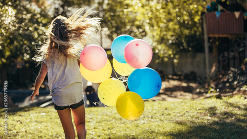 Girl playing outdoors with balloons