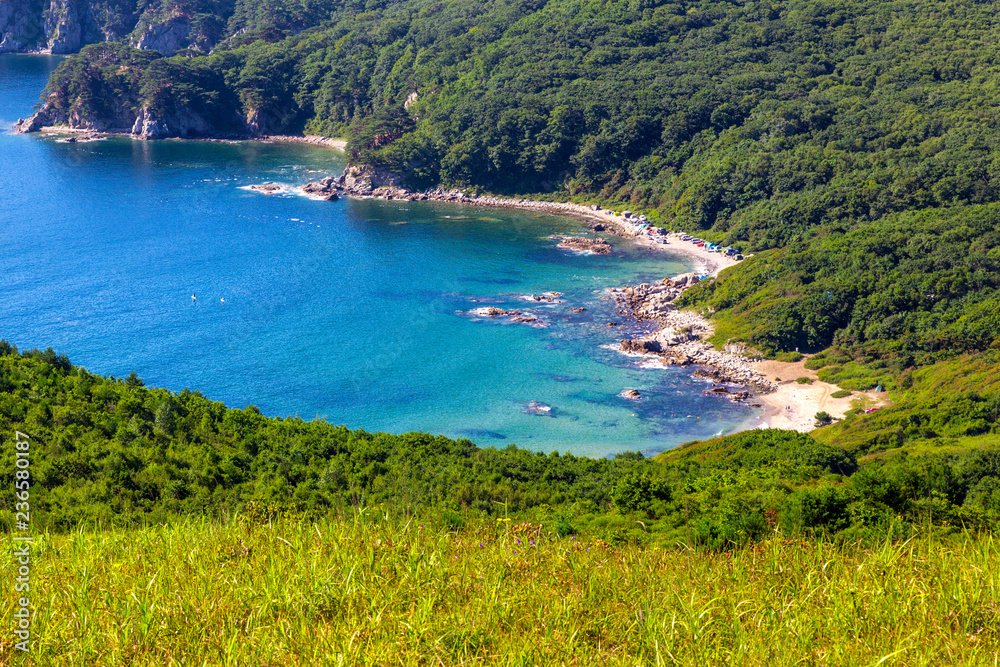 Fototapeta premium View of the beach with turquoise water and green hills in far east of Russia