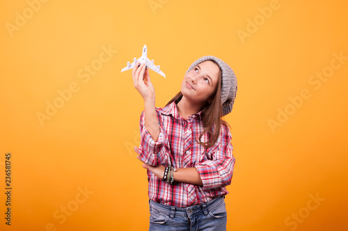 Little girl dreaming to travel around the world while playing with plane toy. Good vibe.