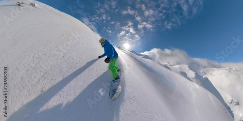 VR360: Pro male snowboarder riding fresh powder in the beautiful backcountry. photo