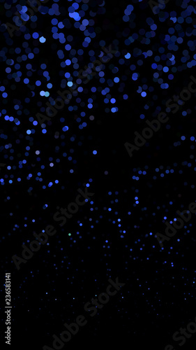 Glowing particles, polka dots on a dark blue background. Vertical festive banner. An elegant holiday pattern. Vector illustration
