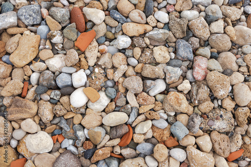 Abstract top view background of many colourful dry stones at sea beach. Horizontal color photography.