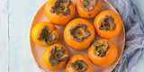 Ripe persimmons on turquoise background