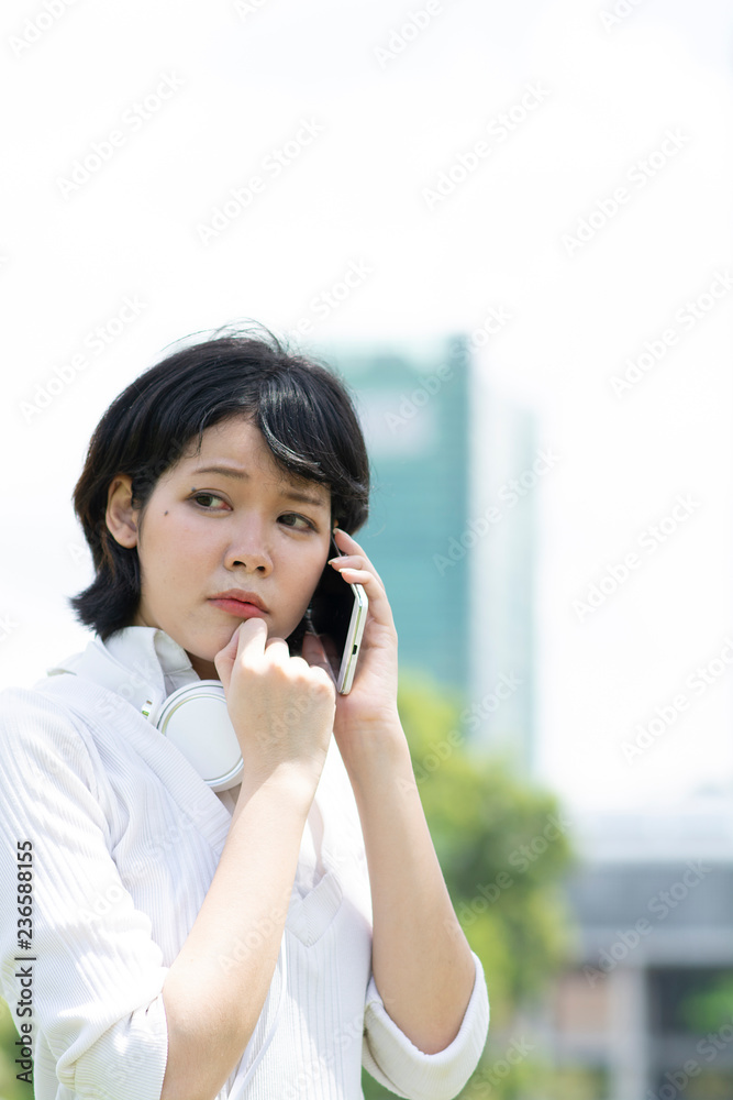Worrying asian woman making phone call in garden Worrying asian woman making phone call in garden