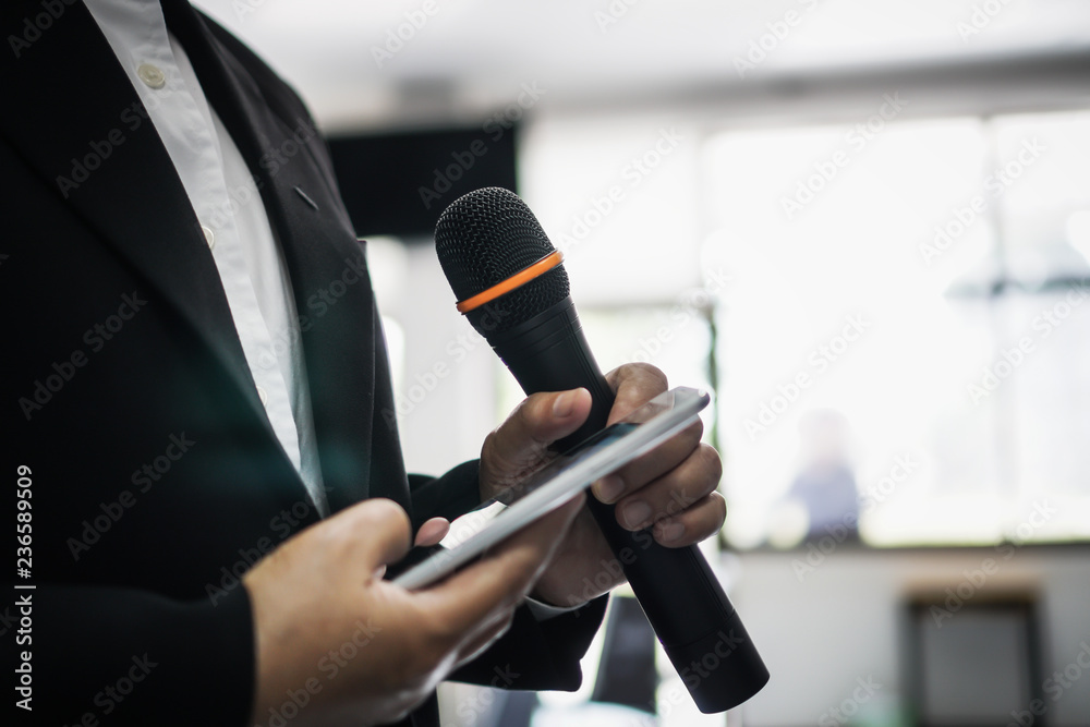 Obraz premium Seminar Conference Concept : hands holding businesspeople speech or speaking with microphones in seminar room, talking for lecture to audience university, Event light convention hall Background.