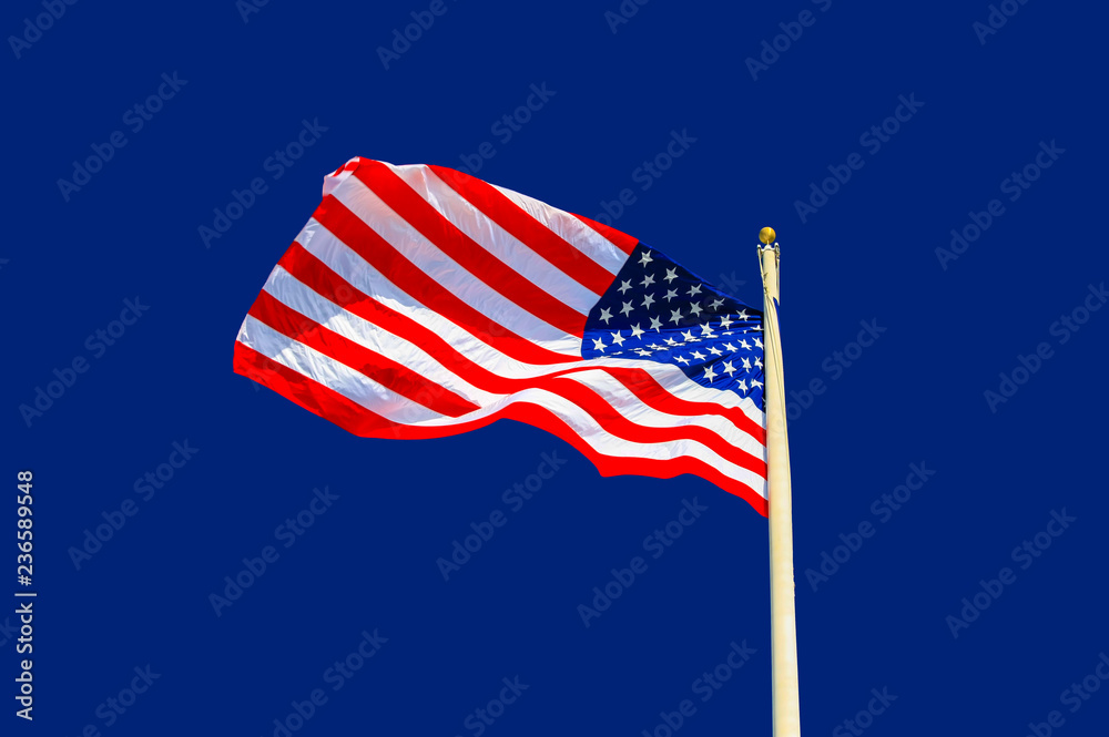 United States national flag waving in the wind against blue background