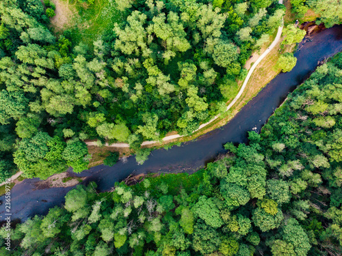 Aerial top down view of summer forest with Vilnele river winding among the trees.