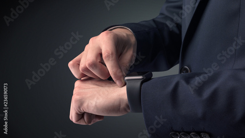 Man wearing suit with smartwatch on his wrist. © ra2 studio