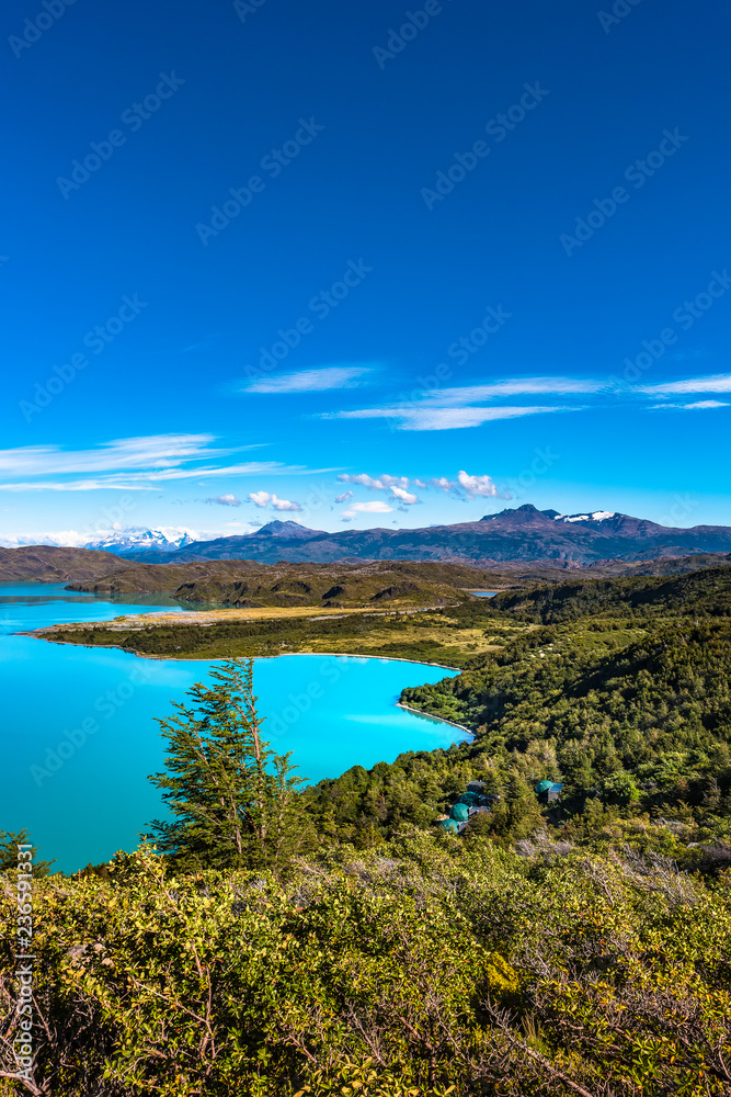 View of Torres del Paine National Park, its forests, lagoon, glaciers and camping site, Patagonia, Chile, sunny day, blue sky