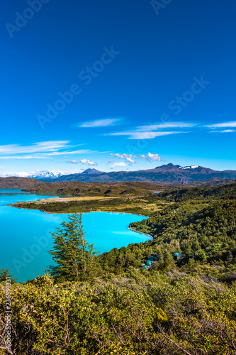 View of Torres del Paine National Park, its forests, lagoon, glaciers and camping site, Patagonia, Chile, sunny day, blue sky