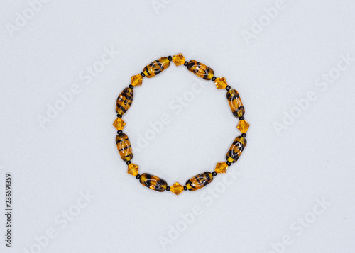 yellow and black colored and variously sized beads bracelet on gray background