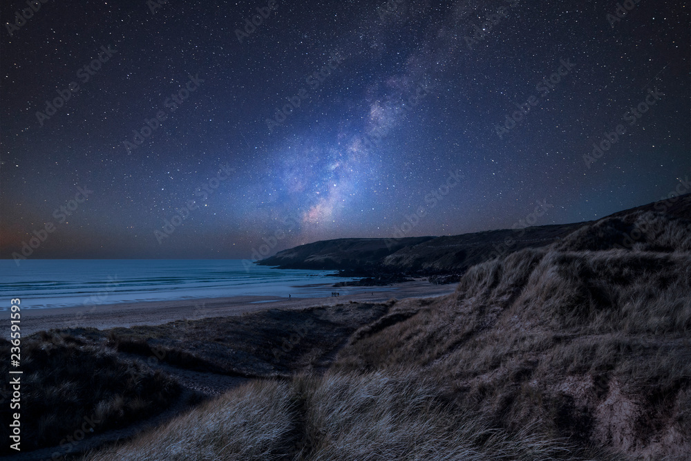 Vibrant Milky Way composite image over landscape of Freshwater West beach in Pembrokeshire Wales