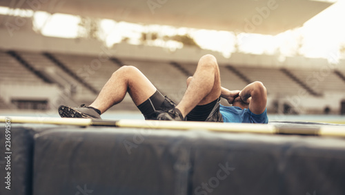 Athlete lying on the high jump landing mat photo