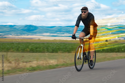 Young riding bicycle in fabulous nature with high speed
