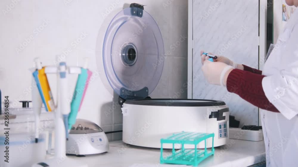 Medical clinic. Nurse putting blood samples in the blood centrifuge Medical clinic. Nurse putting blood samples in the blood centrifuge