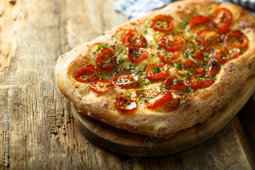 Tomato focaccia with fresh basil photo