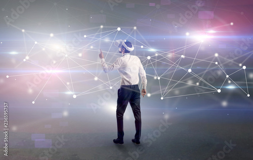 Young businessman standing with vj glasses and checking life-sized connectivity project  