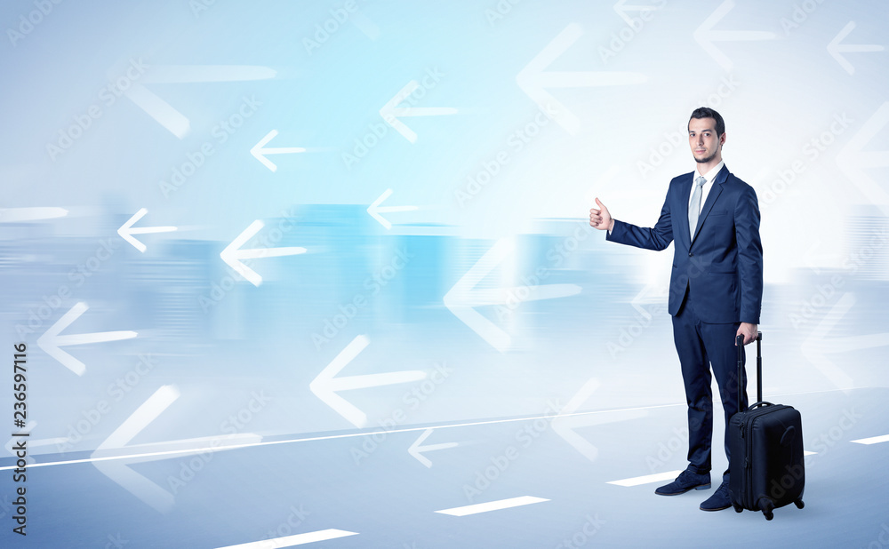 Young businessman hitchhiking near the city with arrows around concept